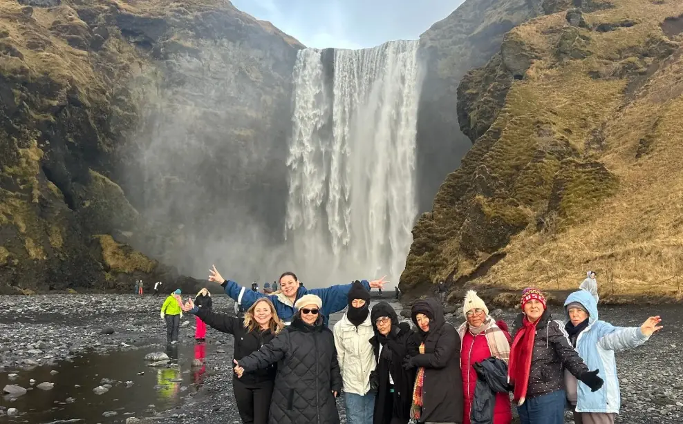Grupo de viajeros de LundiWay frente a la cascada Skógafoss