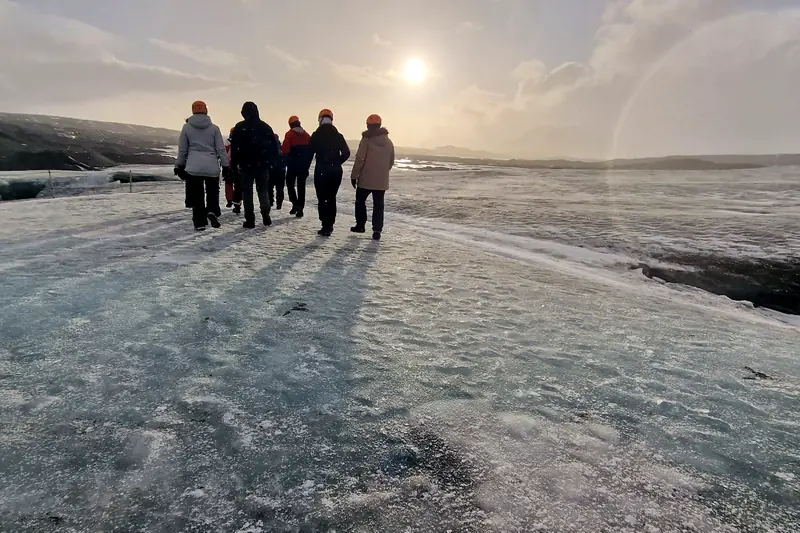 Grupo de viajeros caminando sobre un glaciar en Islandia